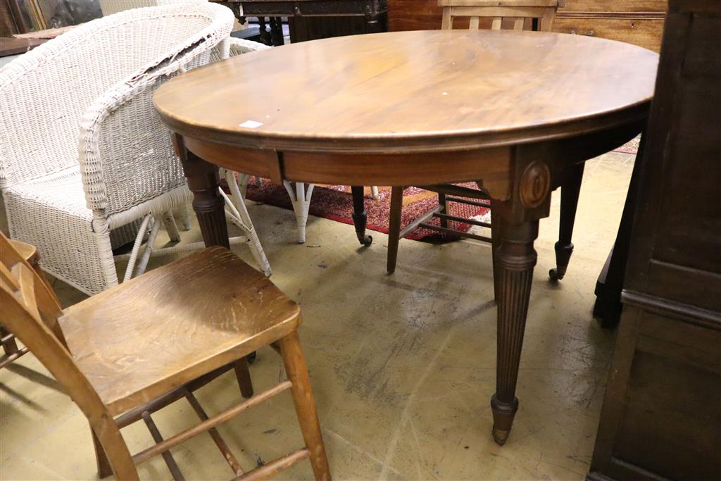 An early 20th century mahogany circular extending dining table, 180cm extended (two spare leaves)